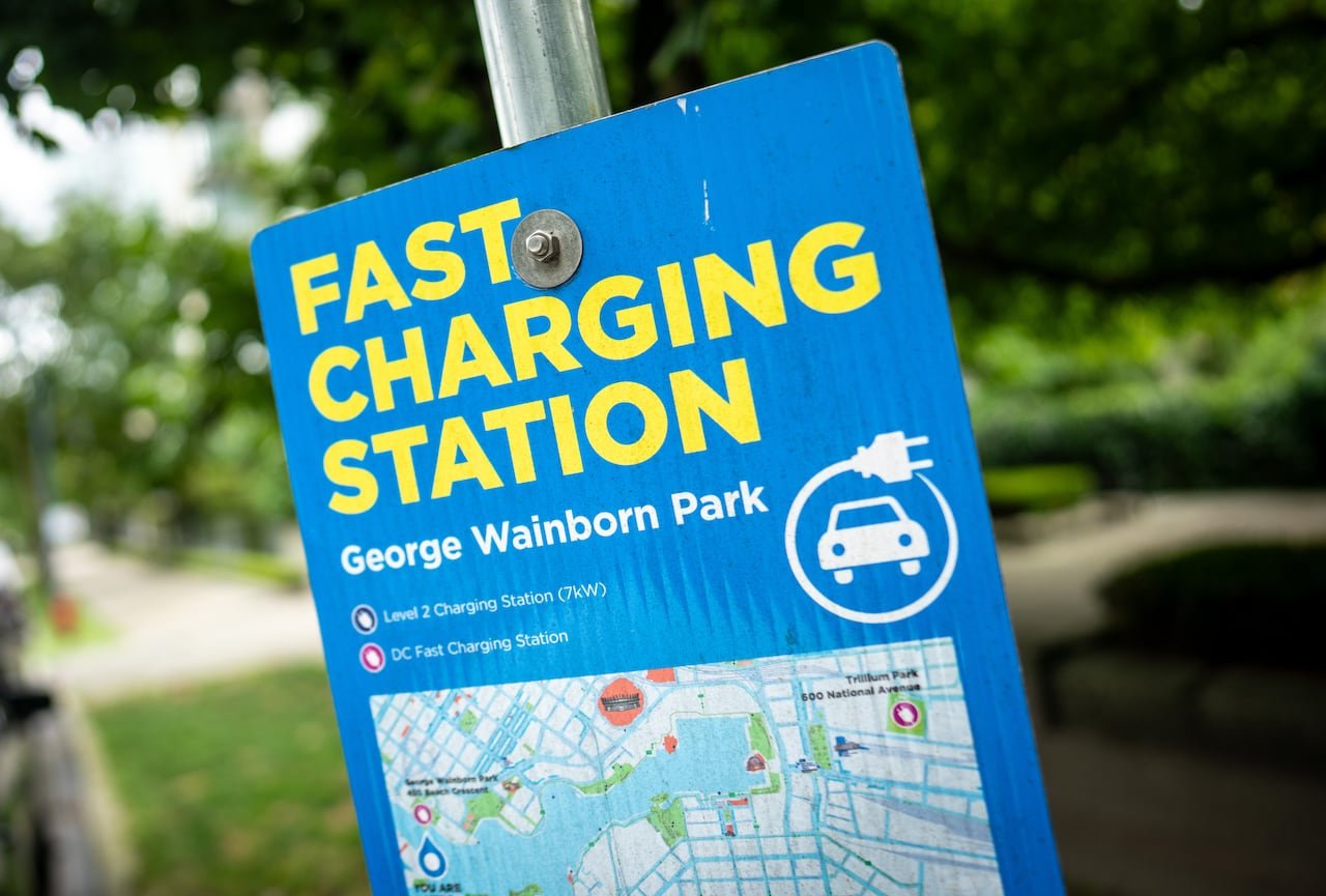 A sign says 'Fast Charging Station George Wainborn Park' on a pole.