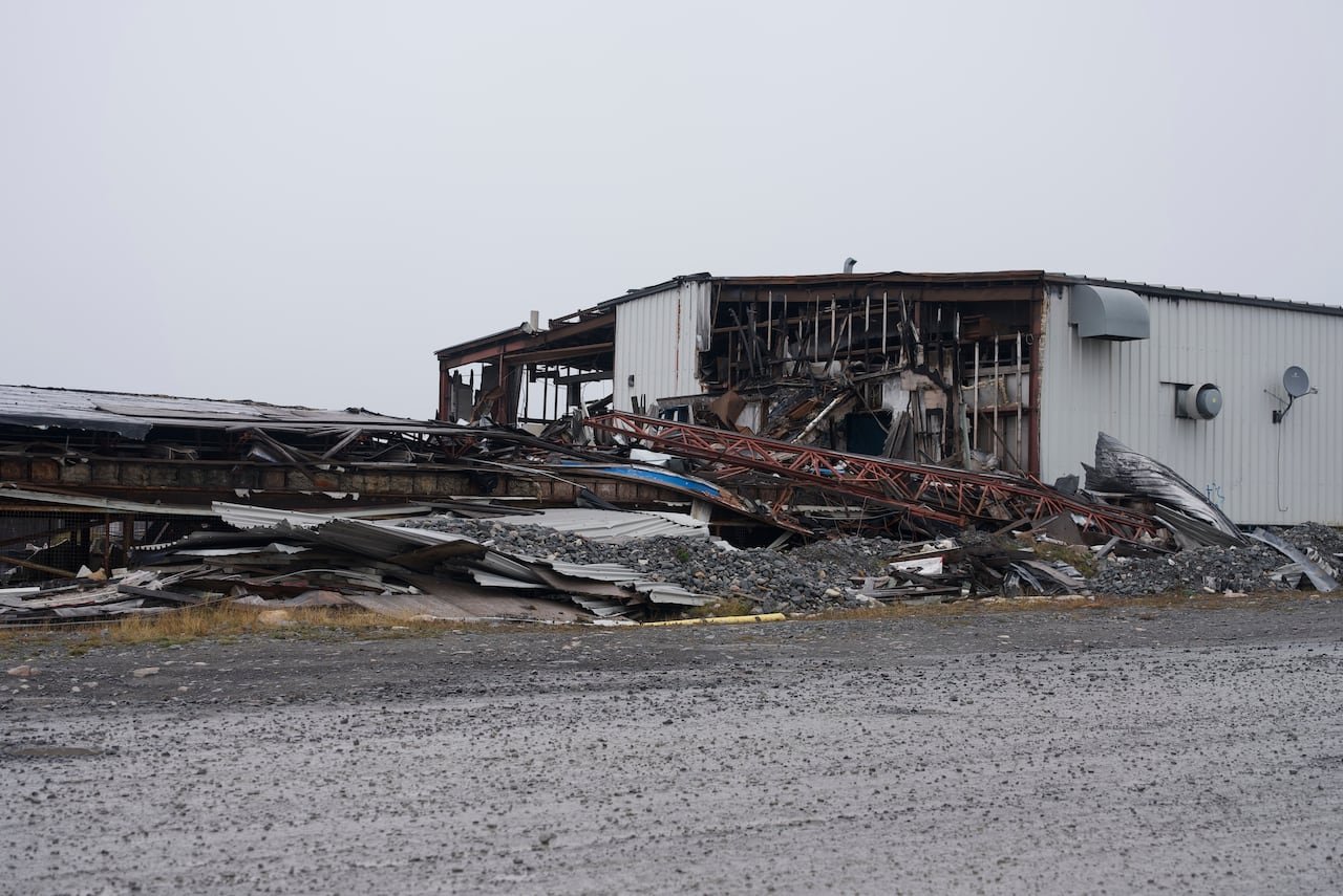 The remains of a building with a large industrial structure next to it.